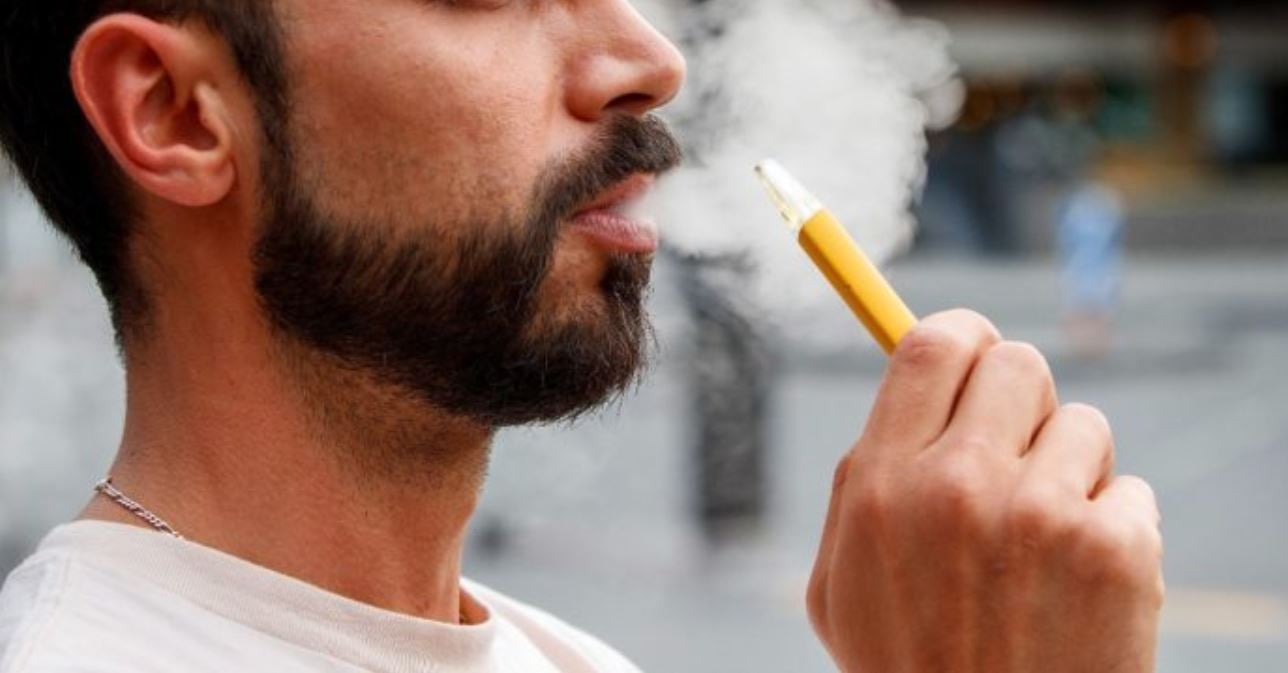 Uomo che fuma sigaretta elettronica